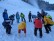 Foto: Schüler*innen im Kreis stehend im Schnee bei Aufwärmübungen.