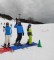 Foto: 3 Schüler*innen auf Skiern auf der Piste winkend.