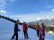 Foto: Schüler*innen und Lehrer auf den Skiern auf dem Berg mit Aussicht auf das Tal
